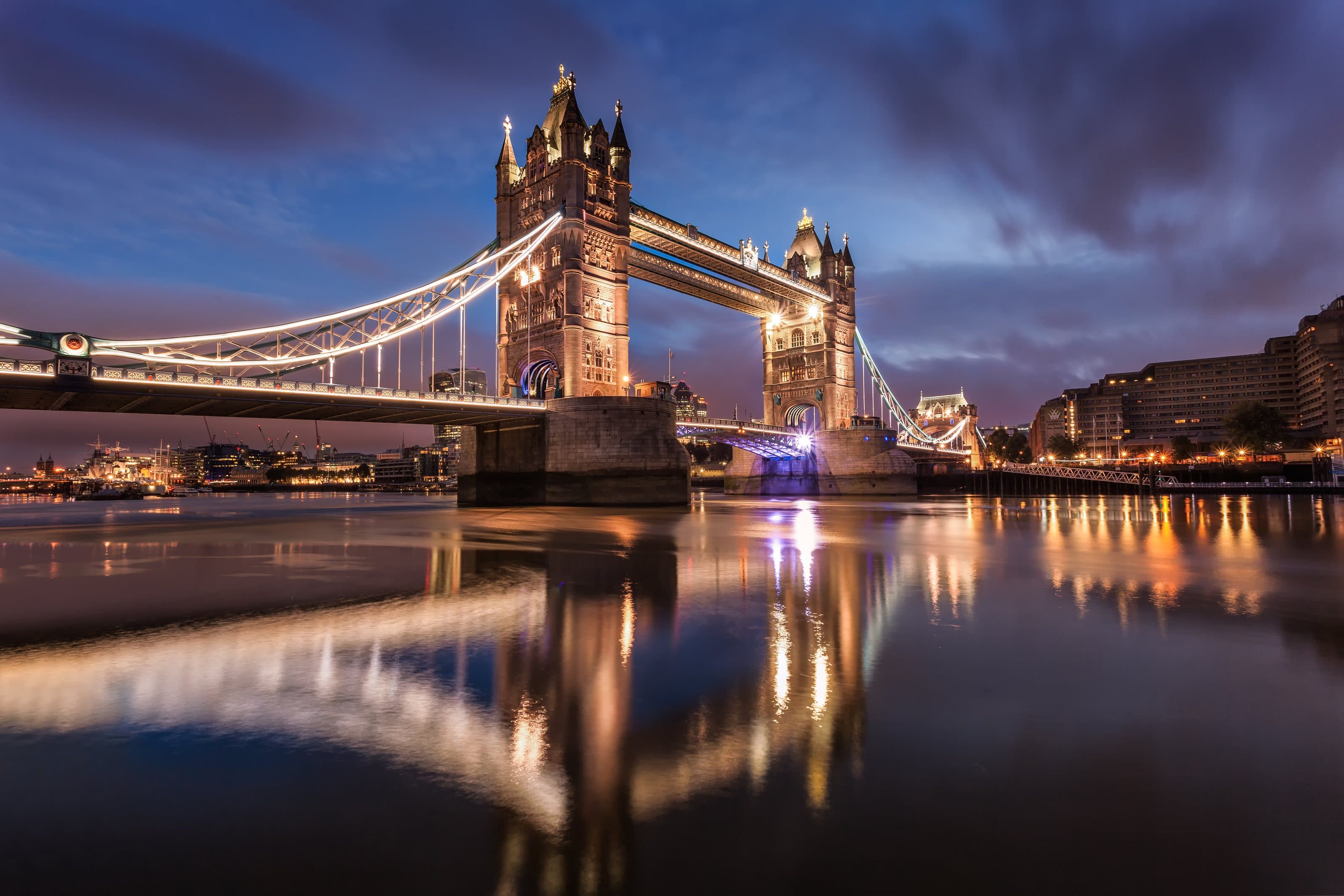Tower Bridge illuminated at blue hour, reflected in the River Thames